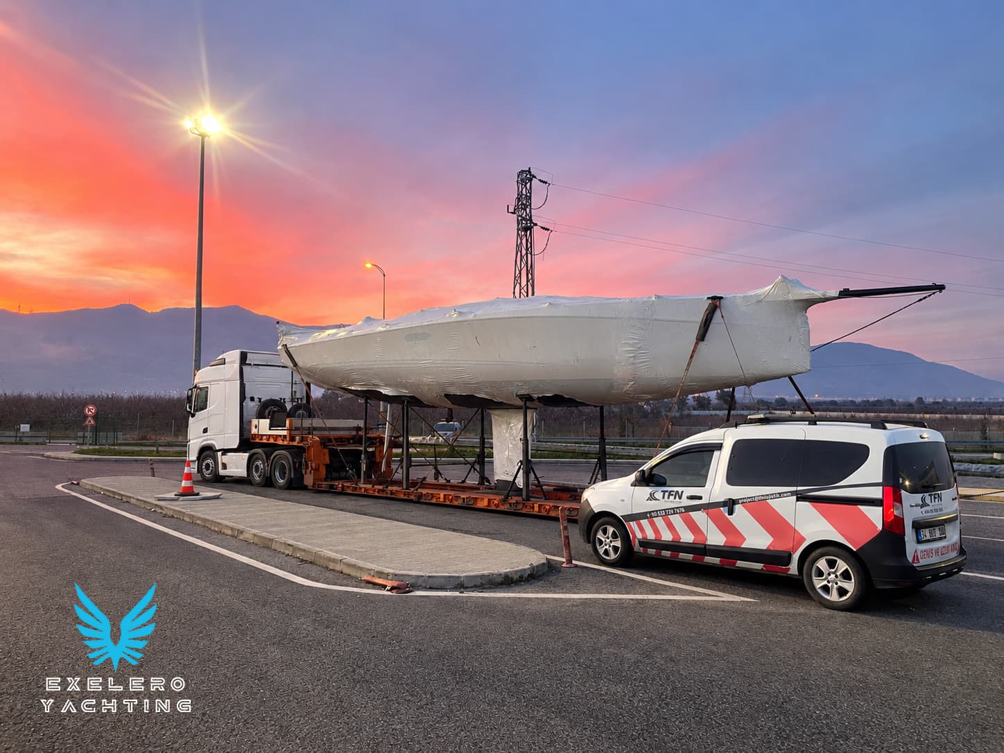 Sailing yacht secured on a road transport trailer at sunset